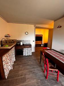 a kitchen with a table and a dining room at Costa Alta - Casa Vacanze in Arcevia