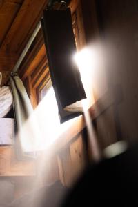 a light shines in a room with a bed and a lamp at The Wagon, rustic off grid experience in Ashbourne