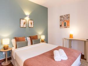 a bedroom with a large bed with two pillows at Foral Guest House in Óbidos