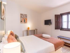a bedroom with a large bed and a tv at Foral Guest House in Óbidos +29 photos