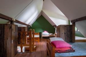 a room with two beds and a green wall at Mchowa Chata in Słupia