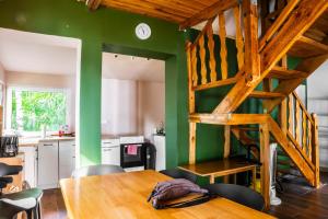a dining room with a wooden table and green walls at Mchowa Chata in Słupia