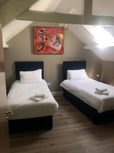 two beds sitting next to each other in a room at Wells House & Gardens Self Catering 3 Bedrooms & Sofa Bed Sleep8 in Glenranny