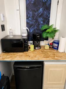 a kitchen counter with a microwave and a coffee maker at Respite room in Chambly