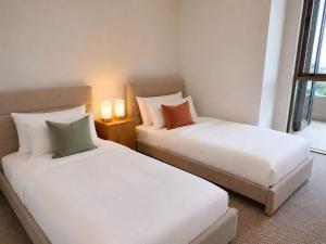 two beds sitting next to each other in a room at Lumi Residence Robina in Gold Coast +14 photos