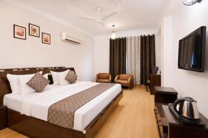 a hotel room with a bed and a flat screen tv at Skylark Hotel by Gabrian Hotels in Gurgaon