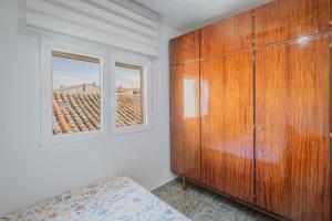 a bedroom with a wooden cabinet and a window at Pisito de Pueblo I I in Navaluenga