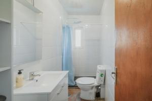 a white bathroom with a toilet and a sink at Pisito de Pueblo I I in Navaluenga +14 photos