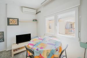 a white room with a table and a tv at Pisito de Pueblo I I in Navaluenga