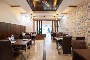 a restaurant with tables and chairs and a brick wall at Skylark Hotel by Gabrian Hotels in Gurgaon