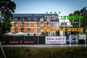 a building with a sign in front of it at Hotel Uniejów in Uniejow
