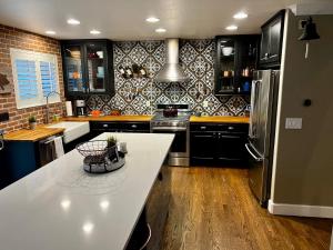 a kitchen with black cabinets and a white counter top at BoCo Bungalow in Superior