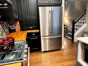 a kitchen with a stainless steel refrigerator and black cabinets at BoCo Bungalow in Superior +24 photos