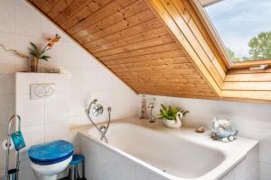 a bathroom with a white tub and a wooden ceiling at Ferienwohnung Zum Leiselsee in Baunatal +27 photos