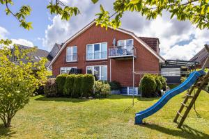 a house with a slide in the yard at Luv Lee Duhnen 06 in Cuxhaven