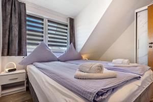 a bedroom with a bed with two towels on it at Luv Lee Duhnen 06 in Cuxhaven