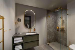 a bathroom with a sink and a mirror and a shower at Dr. Holms Hotel in Geilo