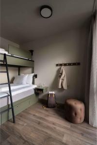 a bedroom with a bunk bed with a ottoman and a chair at Dr. Holms Hotel in Geilo +114 photos