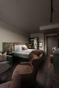 a bedroom with a large bed and a couch at Dr. Holms Hotel in Geilo