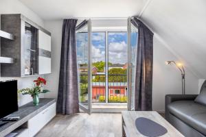 a living room with a couch and a large window at Luv Lee Duhnen 06 in Cuxhaven