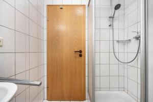a bathroom with a shower and a wooden door at Luv Lee Duhnen 06 in Cuxhaven +21 photos