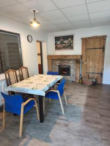 a dining room with a table and chairs and a fireplace at Motoráj -apart Kutná Hora in Kutná Hora