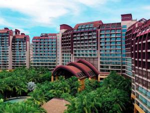 a view of a resort with palm trees and buildings at Pullman Oceanview Sanya Bay Resort & Spa in Sanya