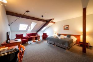 a bedroom with a bed and a living room at LH Hotel Dvořák Tábor Congress & Wellness in Tábor