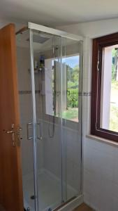a glass shower in a bathroom with a window at Da Elio in Montacuto