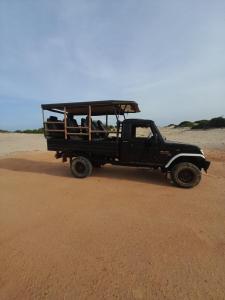 a black pick up truck parked on the beach at Wake N Flow, Arugam Bay in Arugam Bay