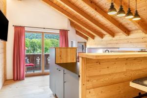 a kitchen with wooden walls and a large window at Ferienwohnung Gipfelblick in Oberau