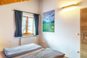 a bedroom with a bed and a picture on the wall at Ferienwohnung Gipfelblick in Oberau