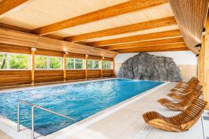 a large swimming pool with chairs in a house at Logis Hôtel & Spa Marina d'Adelphia in Aix-les-Bains