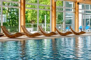 a row of chairs next to a swimming pool at Logis Hôtel & Spa Marina d'Adelphia in Aix-les-Bains
