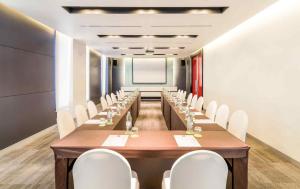 a conference room with a long table and white chairs at Ibis Bangkok Sukhumvit 4 in Bangkok +20 photos
