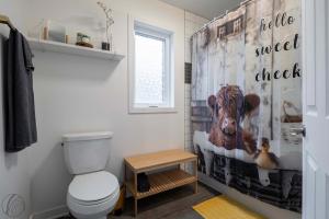 a bathroom with a toilet and a cow shower curtain at Ours noir spa waterfront in Chertsey +57 photos