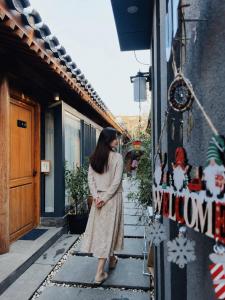 a woman standing on the steps of a building at Beijing Templeside Courtyard Hotel 丨 3 metros to the Square丨Free laundry, personalized services large terrace in Beijing +125 photos