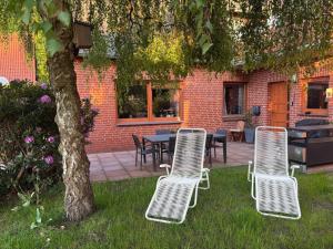 a group of chairs and a table and a tree at Am Storchennest in Walsrode
