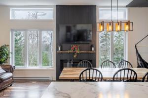a living room with a table and chairs and a fireplace at Ours noir spa waterfront in Chertsey