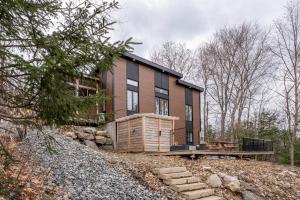 a house on top of a hill with trees at Ours noir spa waterfront in Chertsey