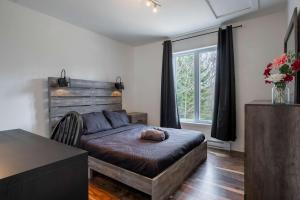a bedroom with a bed and a large window at Ours noir spa waterfront in Chertsey