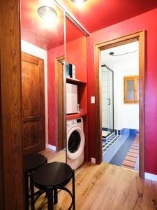 a laundry room with red walls and a washing machine at La Donota in Trieste