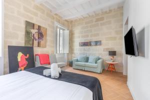 a bedroom with a bed and a living room at Suite 2 in Mahón