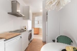a white kitchen with a sink and a washing machine at Suite 2 in Mahón +12 photos