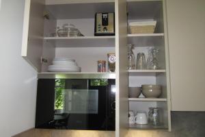 a kitchen shelf with dishes and other items on it at Aan de Dijk in Edam +19 photos