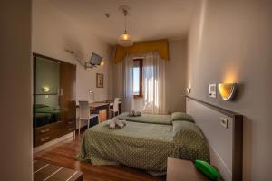 a bedroom with a bed and a desk in it at Hotel Cristallo - Chianciano Terme in Chianciano Terme