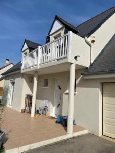 a white house with a balcony on top of it at Maison avec balcon in Saint-Hilaire-Petitville