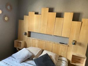 a bed with wooden panels on the wall at Maison avec balcon in Saint-Hilaire-Petitville
