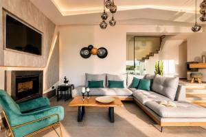 a living room with a couch and chairs and a fireplace at Villa Vatia 3 in Tragaki