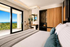 a bedroom with a bed and a large window at Villa Vatia 3 in Tragaki +19 photos